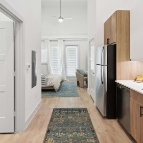 Kitchen Hallway kitchen with wood-like flooring and modern appliances